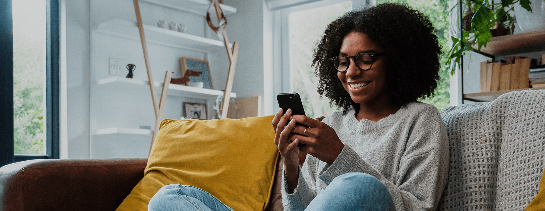 Woman reading our first home buyer blog while sitting on the couch